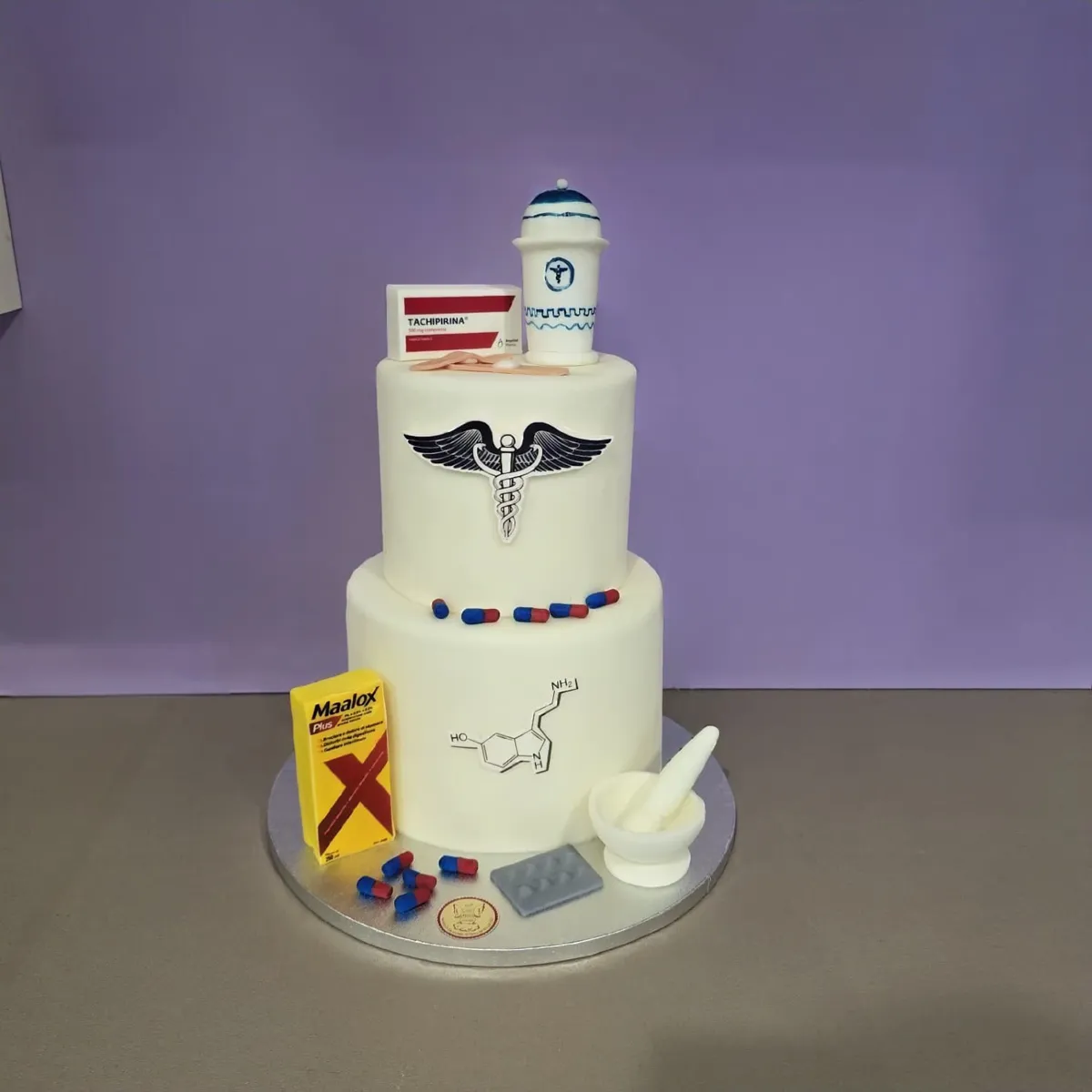 Torta di laurea in farmacia con caduceo, pillole e mortaio