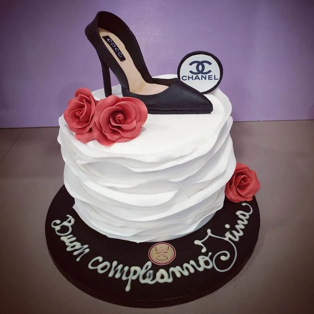 Torta bianca a balze con scarpa con tacco e rose rosse